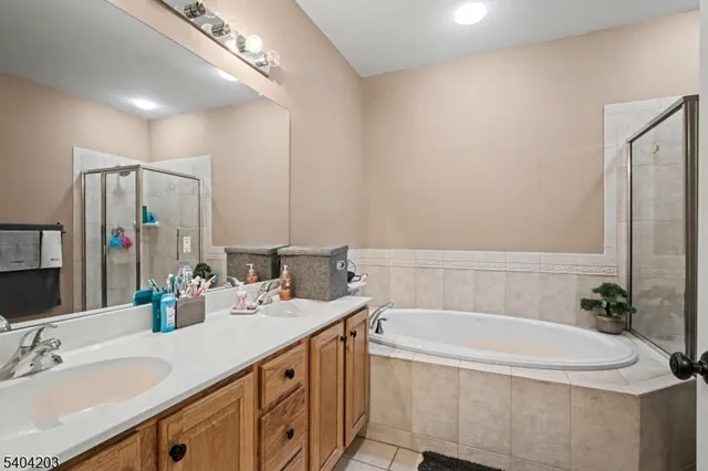 a bathroom with a tub a sink and mirror