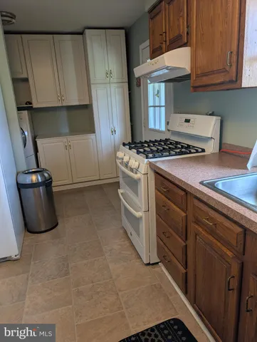 a kitchen with granite countertop a stove and a sink