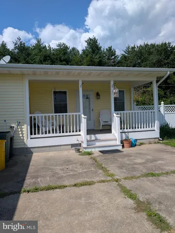 a view of a house with a floor to ceiling window and a yard