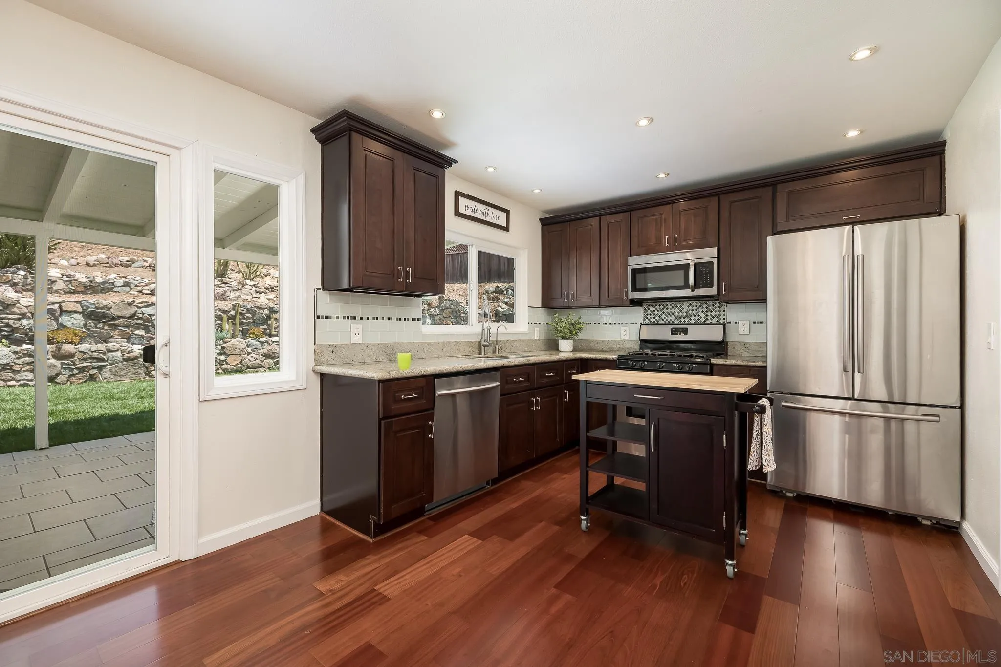 9731 Domer Road Santee, CA 92071 - Photo 11 of 32 a kitchen with kitchen island wooden floors white appliances and cabinets