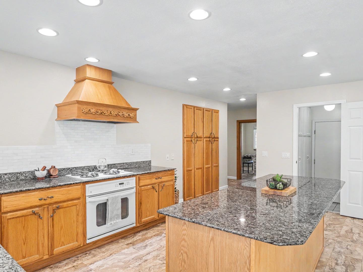 6455 Kensington Place Gilroy, CA 95020 - Photo 12 of 32 a kitchen with stainless steel appliances granite countertop a sink a stove and a wooden cabinets