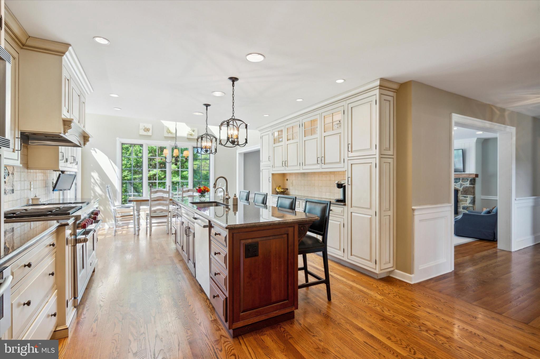 792 Avonwood Drive Wayne, PA 19087 - Photo 11 of 35 a kitchen with stainless steel appliances kitchen island granite countertop a stove a refrigerator a dining table and chairs with wooden floor