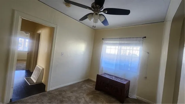 a view of a hallway with a chandelier fan and wooden floor