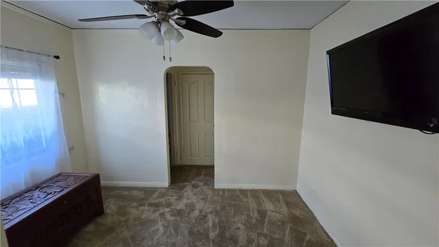 a view of empty room with a flat tv screen and a fan