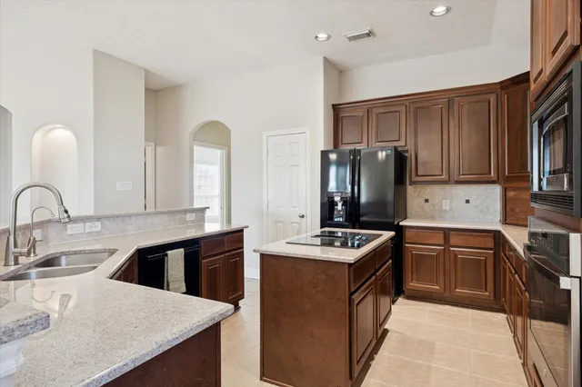 a kitchen with stainless steel appliances granite countertop a stove refrigerator sink and cabinets