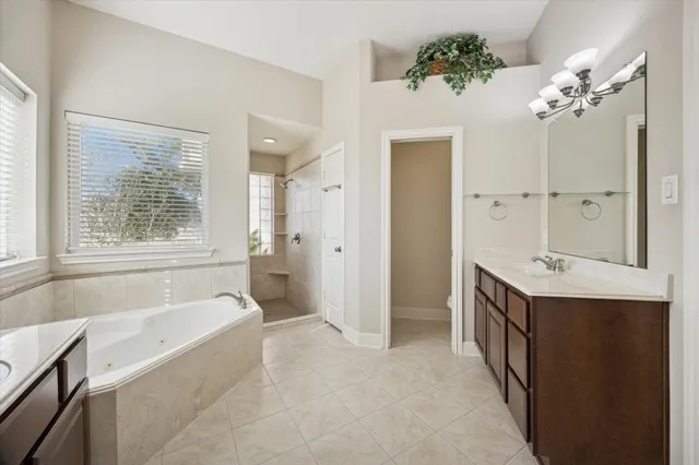 a spacious bathroom with a tub sink shower and mirror