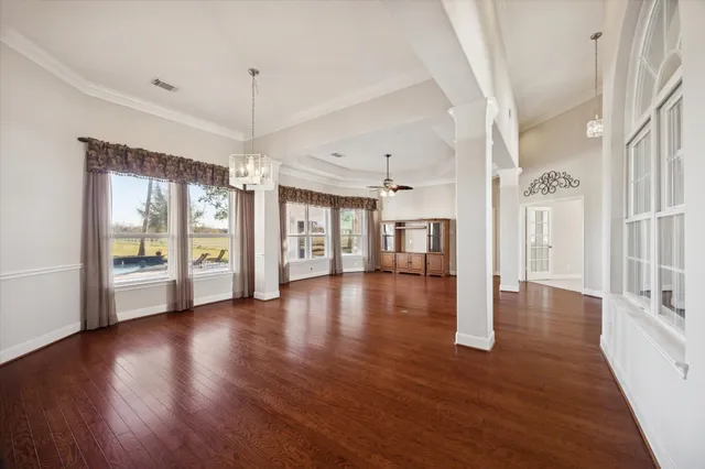 a view of a big room with wooden floor and windows