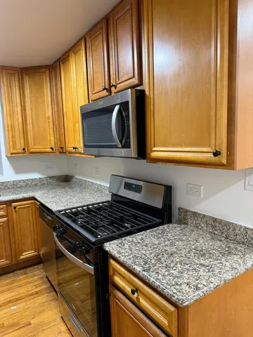 a kitchen with granite countertop cabinets and black stainless steel appliances