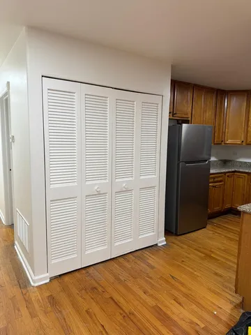 a view of a kitchen with wooden cabinet