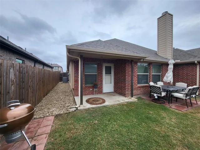 a view of a backyard with table and chairs and wooden fence