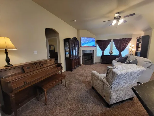 a living room with furniture a chandelier and a piano