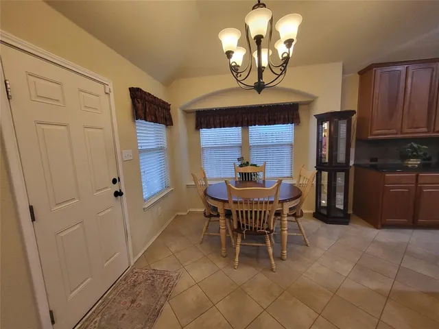 a view of a dining room with furniture and chandelier