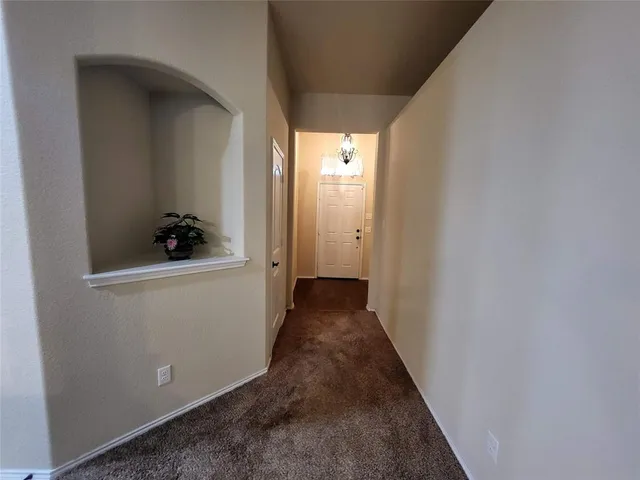 a view of a hallway with wooden floor and closet