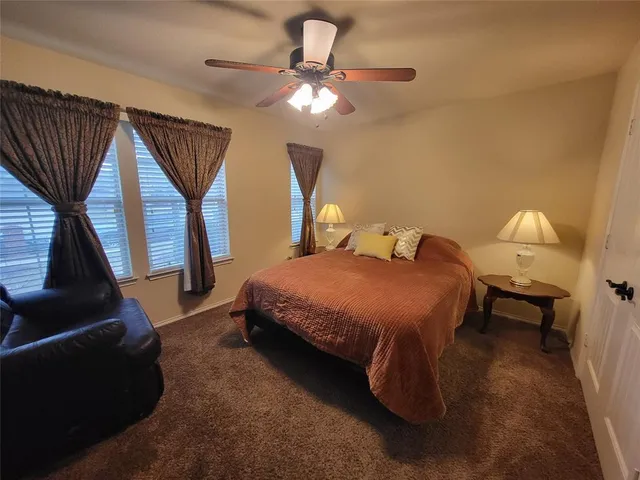 a spacious bedroom with a bed and a chandelier