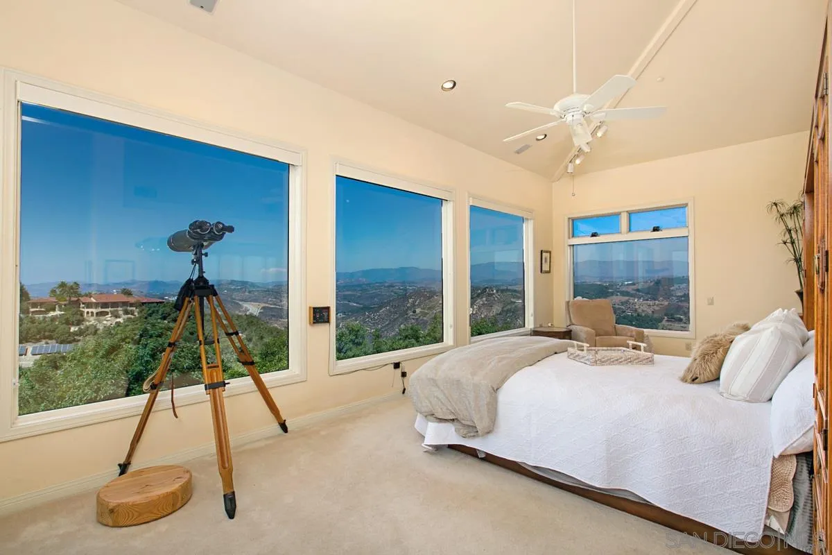 1629 Wild Acres Road Vista, CA 92084 - Photo 17 of 34 a bedroom with a bed and a chandelier