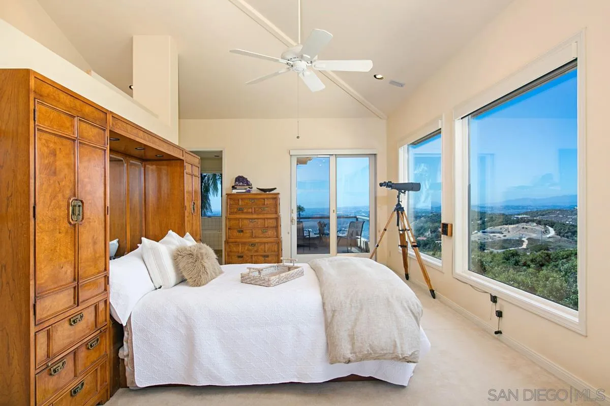 1629 Wild Acres Road Vista, CA 92084 - Photo 18 of 34 a spacious bedroom with a bed and glass walk in closet