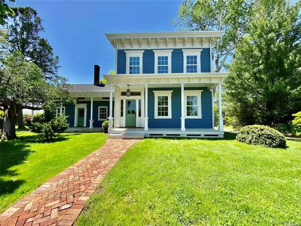 a front view of a house with yard and green space