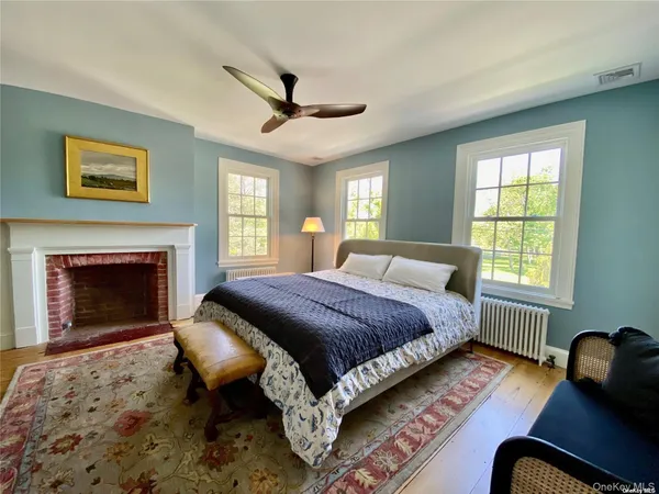 a spacious bedroom with a bed a couch and a fireplace