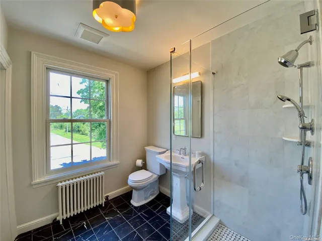 a bathroom with a toilet a sink and a window