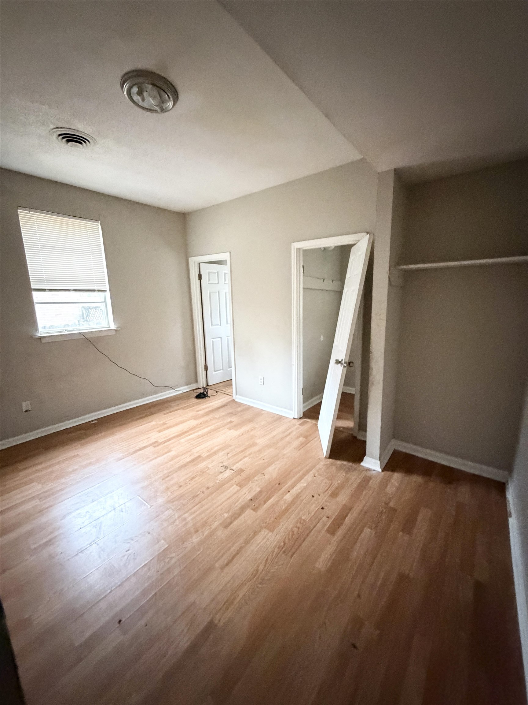 278 Hewlett Road Memphis, TN 38109 - Photo 7 of 13 an empty room with wooden floor and windows
