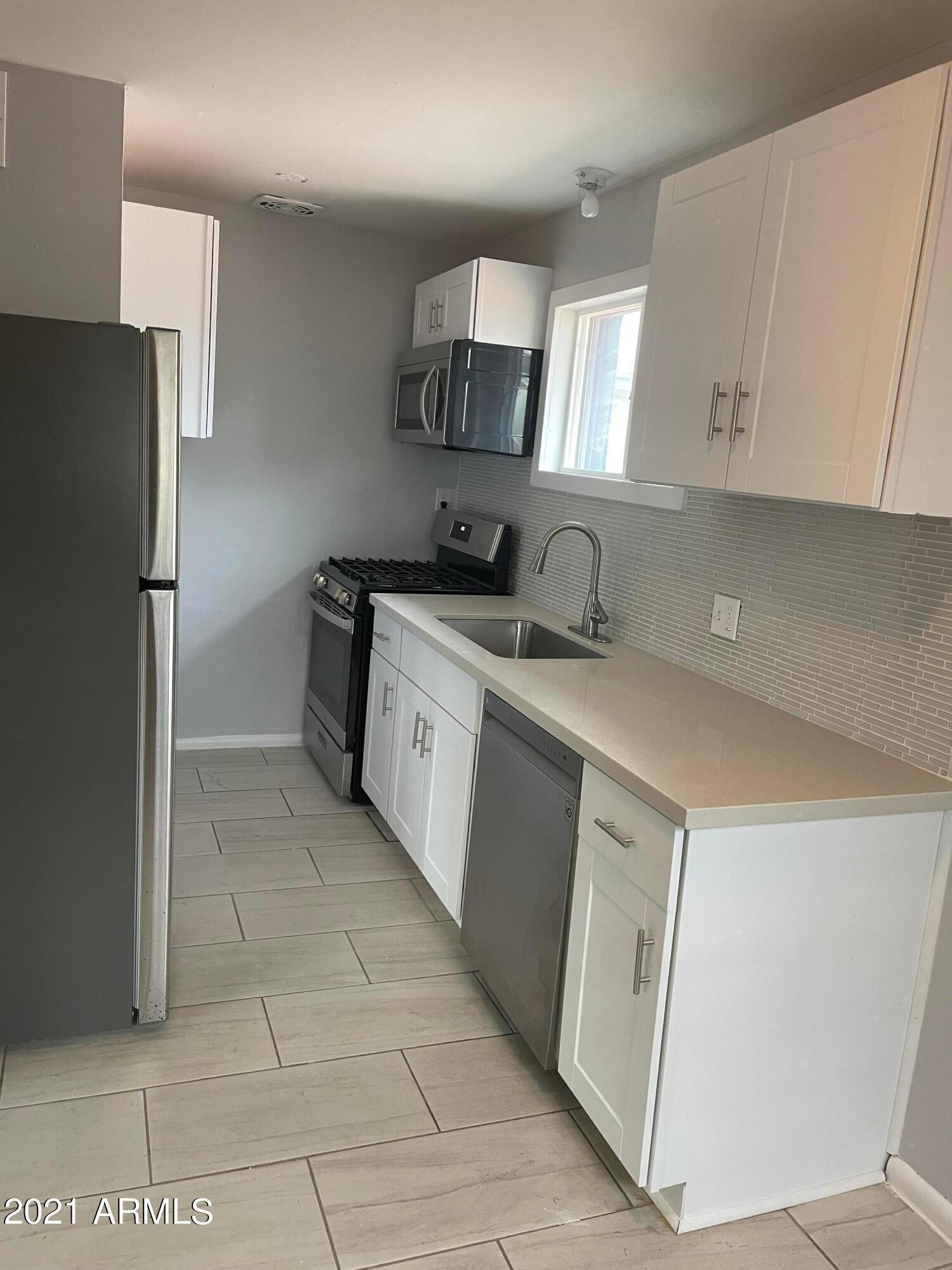 2242 North 29th Place, Unit 3 Phoenix, AZ 85008 - Photo 3 of 19 a kitchen with stainless steel appliances granite countertop a sink stove and refrigerator