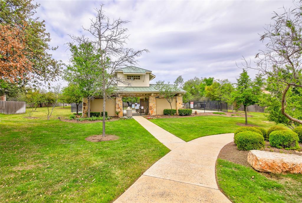 3451 Mayfield Ranch Boulevard, Unit 340 Round Rock, TX 78681 - Photo 10 of 13 A well-maintained pathway leads to a charming community building, framed by verdant landscaping.