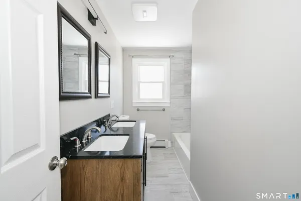 a bathroom with a granite countertop sink and a mirror