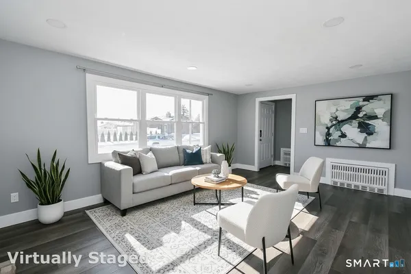 a living room with furniture potted plant and a window