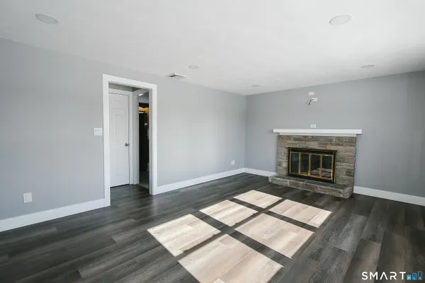 wooden floor fireplace and windows in an empty room