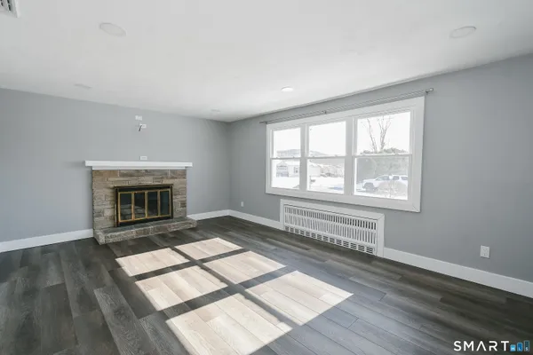 an empty room with windows and fireplace