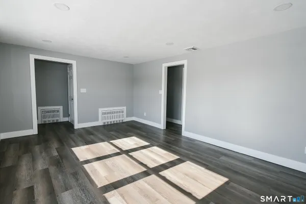 a view of a room with wooden floor and windows