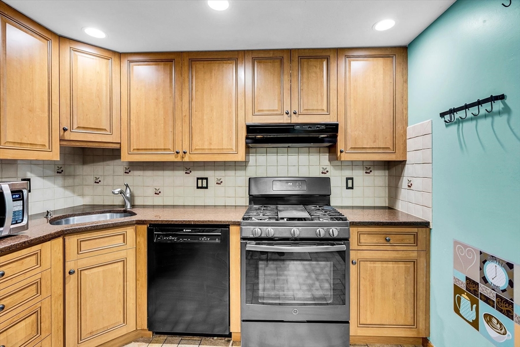 74 Meeting House Path, Unit 74 Ashland, MA 01721 - Photo 12 of 33 a kitchen with stainless steel appliances granite countertop a stove a sink and a microwave