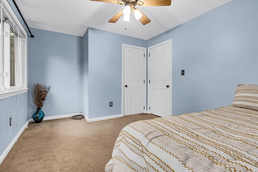 74 Meeting House Path, Unit 74 Ashland, MA 01721 - Photo 15 of 33 a bedroom with a large bed and a chandelier