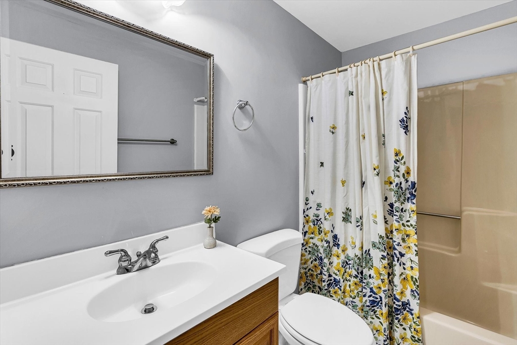 74 Meeting House Path, Unit 74 Ashland, MA 01721 - Photo 16 of 33 a bathroom with a sink a toilet and shower curtain
