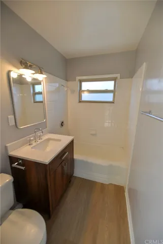 a bathroom with a granite countertop sink a toilet and a mirror
