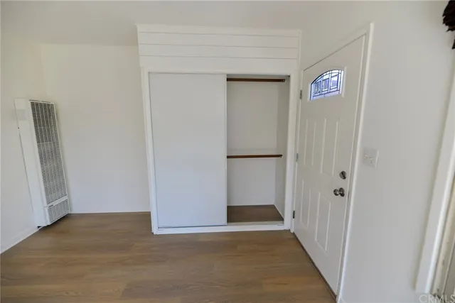 a view of a hallway with wooden floor and closet