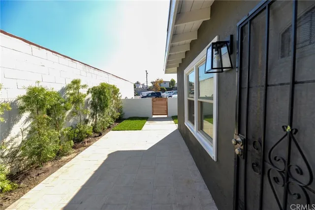 a view of a balcony with wooden floor and fence and potted plants