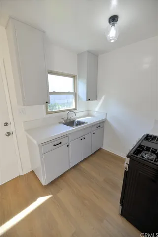 a kitchen with a sink stove and cabinets