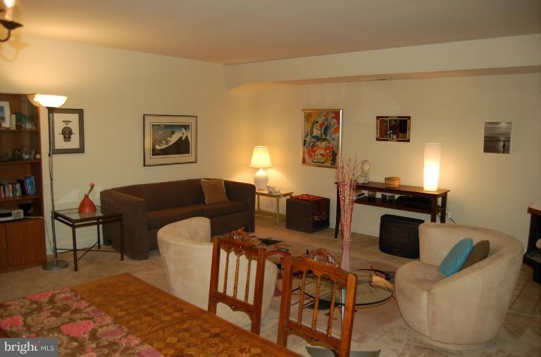 8663 Geren Road, Unit 265 Silver Spring, MD 20901 - Photo 3 of 9 a living room with furniture a flat screen tv and a table