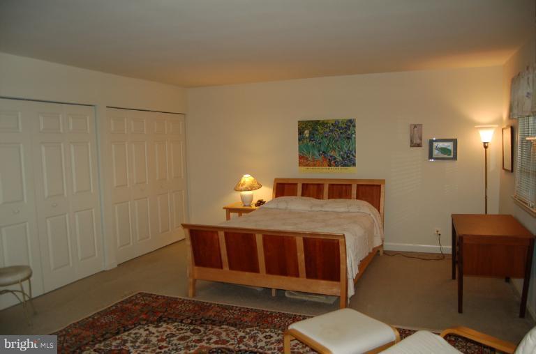 8663 Geren Road, Unit 265 Silver Spring, MD 20901 - Photo 8 of 9 a bed sitting in a bedroom next to a small bathroom