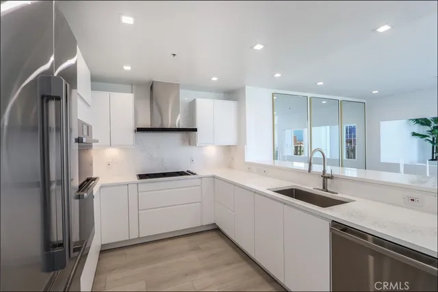 a kitchen that has a sink and a refrigerator in it