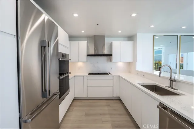 a kitchen with stainless steel appliances granite countertop a sink and a refrigerator