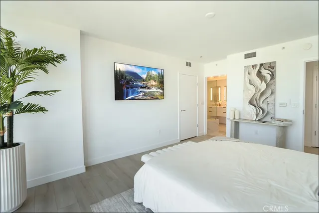 a bedroom with a large bed and a potted plant