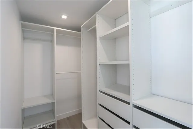 a view of walk in closet with empty racks