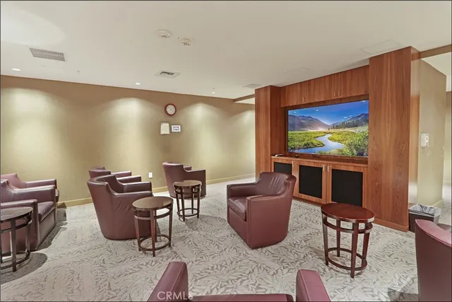 a living room with furniture a flat screen tv and floor to ceiling window