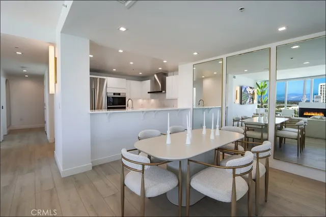 a kitchen with a dining table chairs and wooden floor