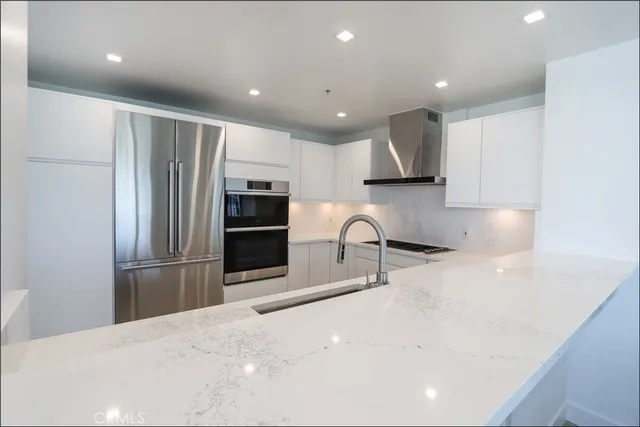 a kitchen with stainless steel appliances a refrigerator sink and microwave