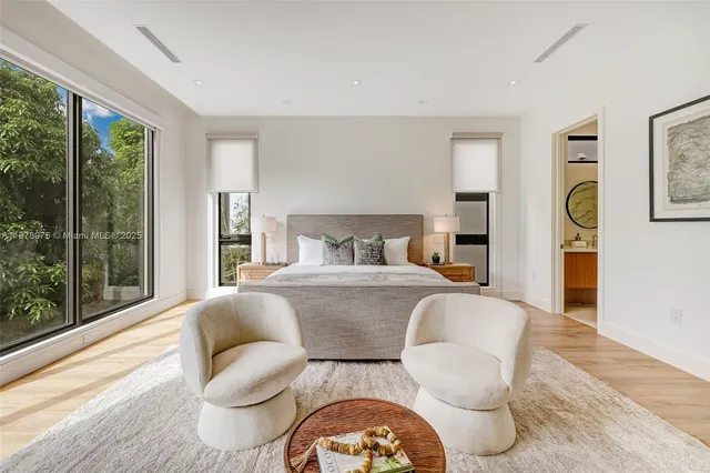 a bedroom with furniture and a large window