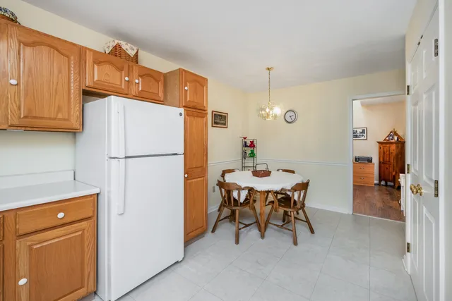a kitchen with refrigerator a table and chairs