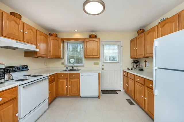 a kitchen with white cabinets and white appliances